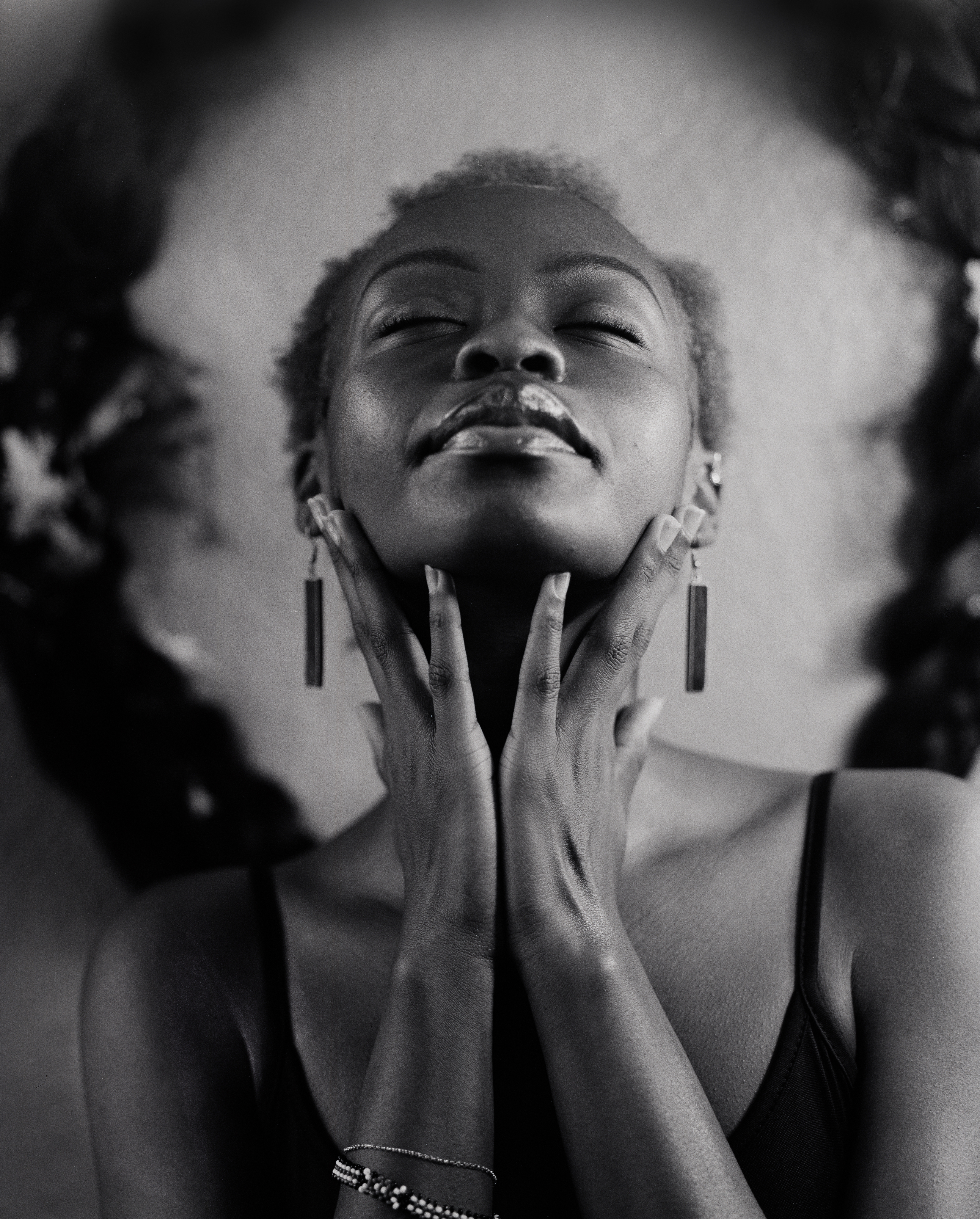 Woman in a suit, holding a flower, bathed in warm light