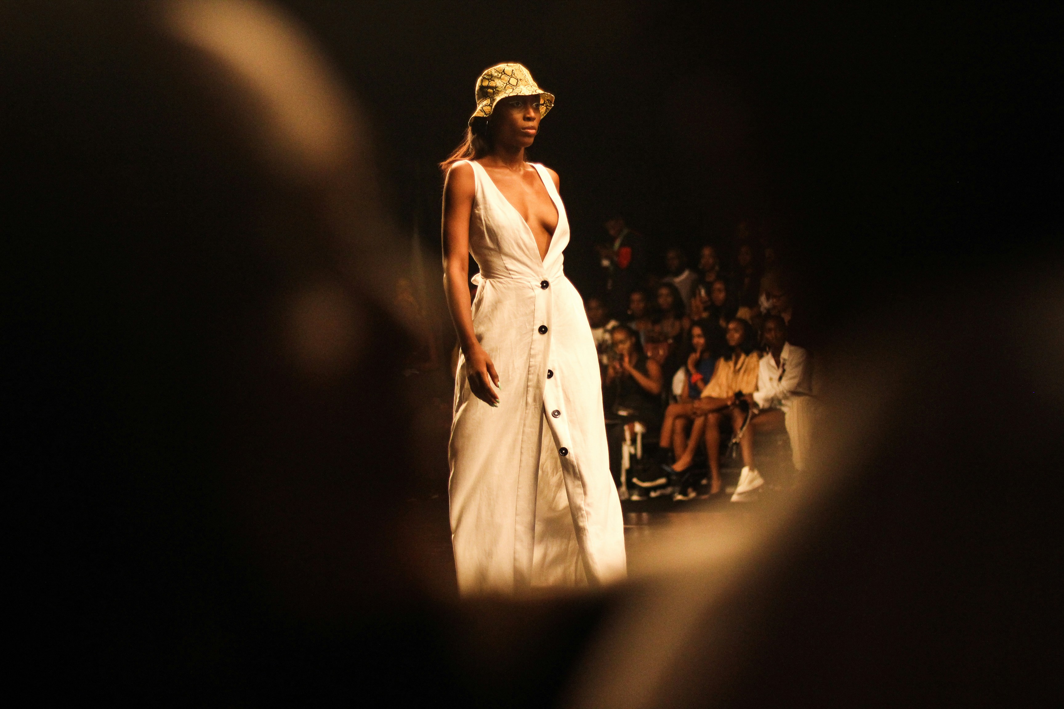 Woman with sunglasses walking down runway
