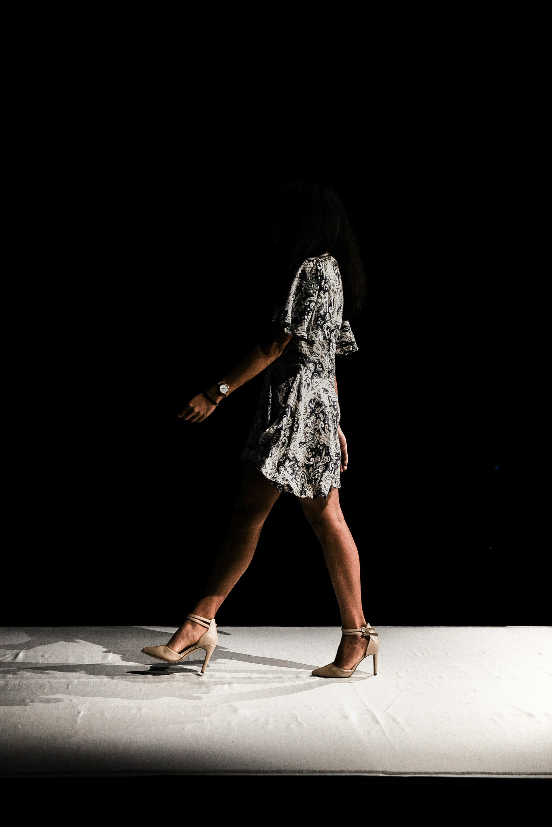 Woman with sunglasses walking down runway
